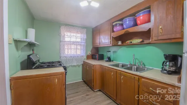 a kitchen with kitchen island a sink stainless steel appliances and wooden floor