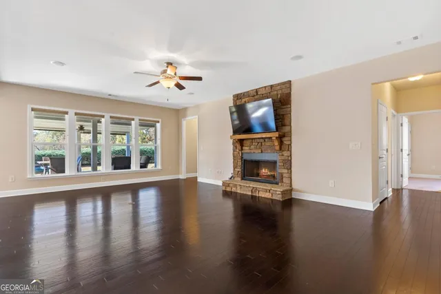 a view of empty room with fireplace and wooden floor