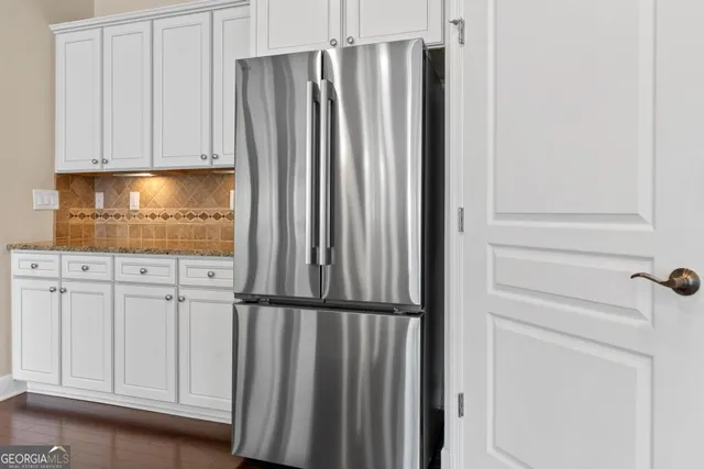 a kitchen with stainless steel appliances white cabinets and a stove top oven