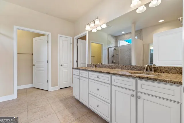 a bathroom with a granite countertop sink mirror and shower