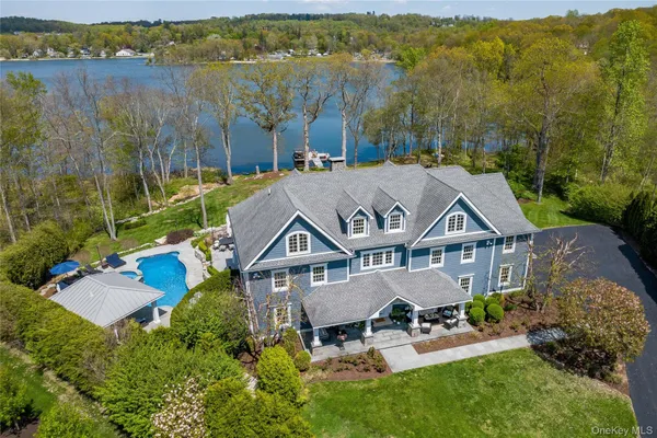 an aerial view of a house with a garden and lake view
