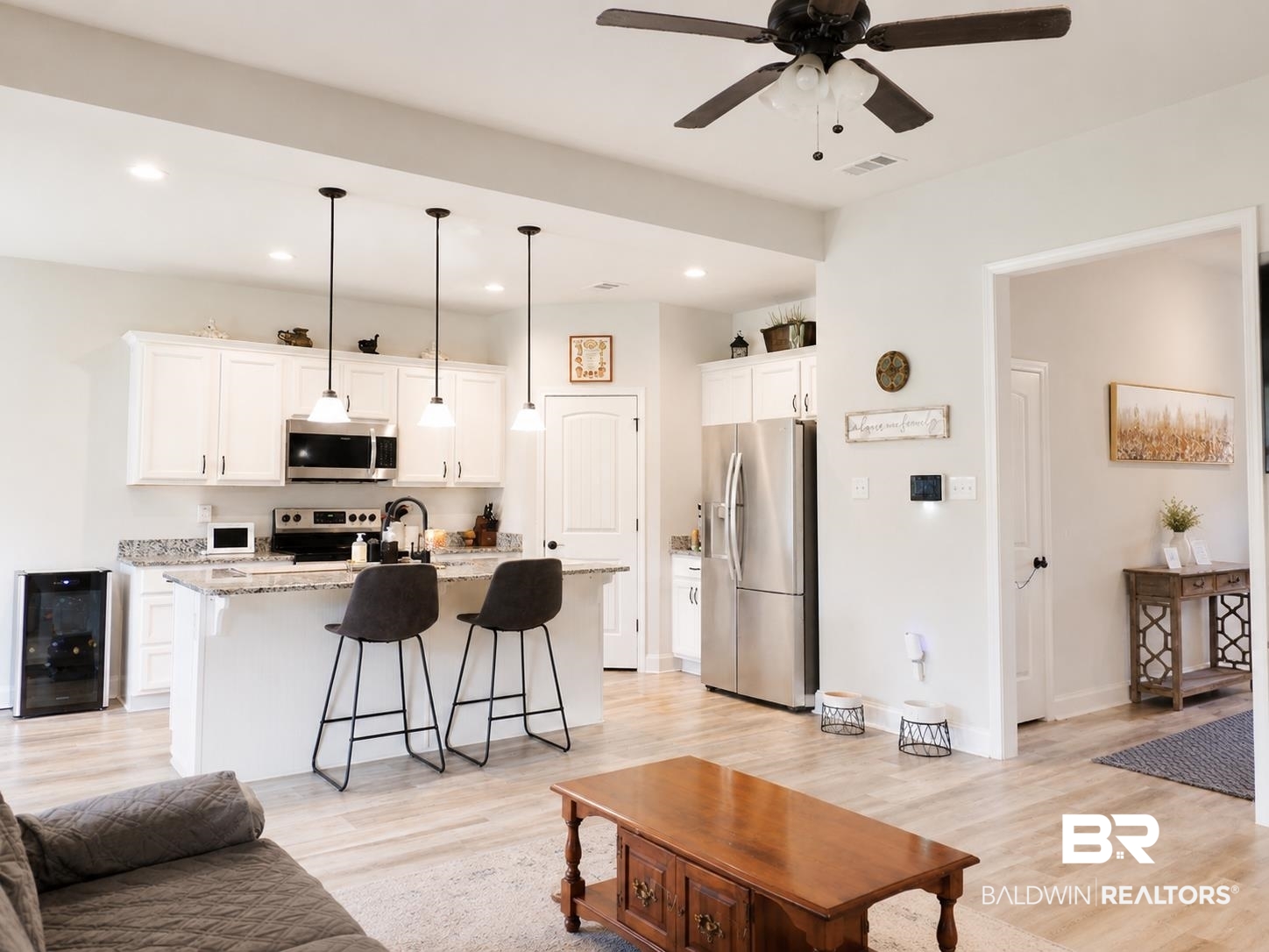 1097 Stella Road Foley, AL 36535 - Photo 7 of 15 Open-concept kitchen featuring white cabinetry, stainless steel appliances, granite-style countertops, an island with pendant lighting, and wood-finish flooring