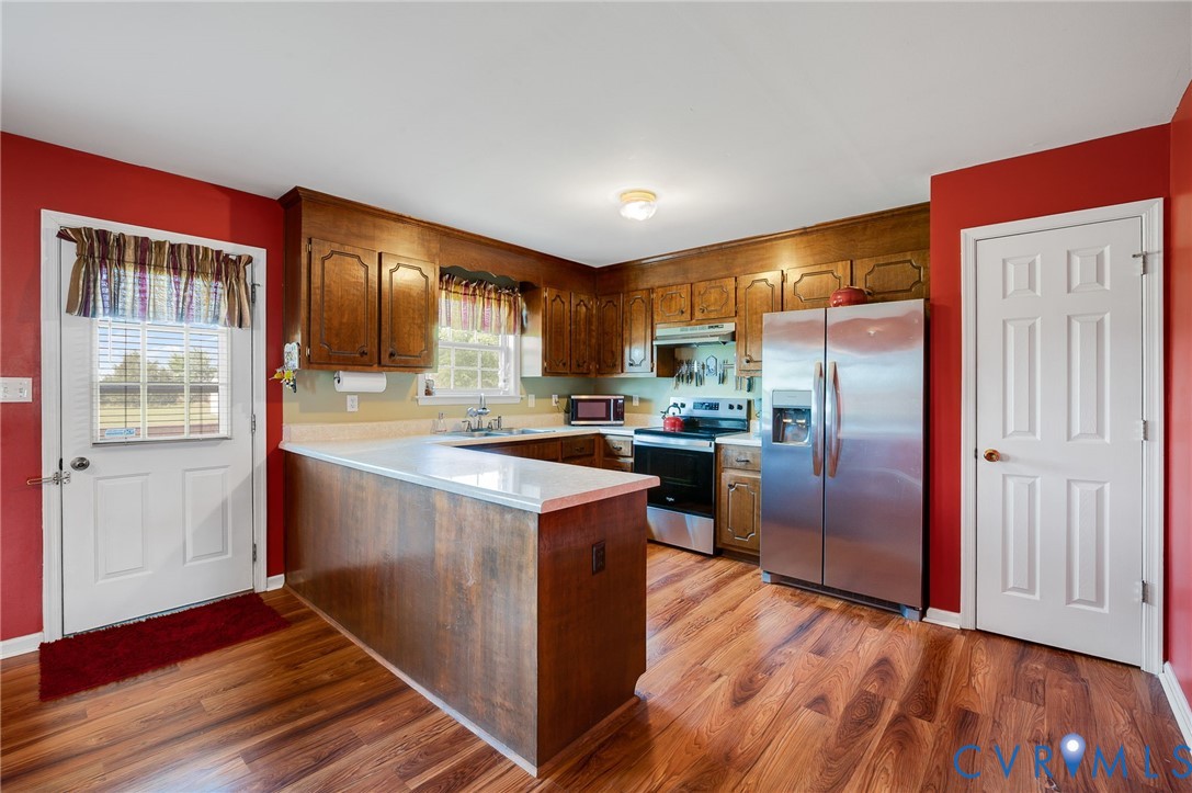 5280 West Quaker Road Disputanta, VA 23875 - Photo 25 of 33 a kitchen with stainless steel appliances granite countertop a refrigerator a sink dishwasher a stove and white countertops with wooden floor