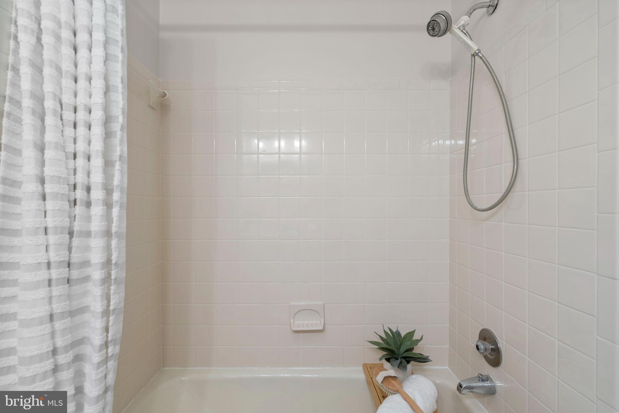 2126 Golf Course Drive Reston, VA 20191 - Photo 25 of 48 a bathroom with a shower curtain and a shower
