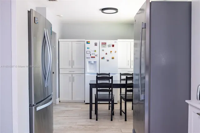 a kitchen with stainless steel appliances kitchen island granite countertop a refrigerator and a stove