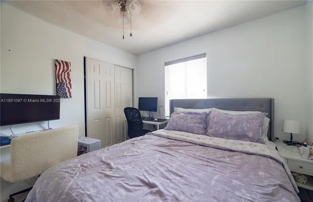 a spacious bedroom with a bed and a flat screen tv