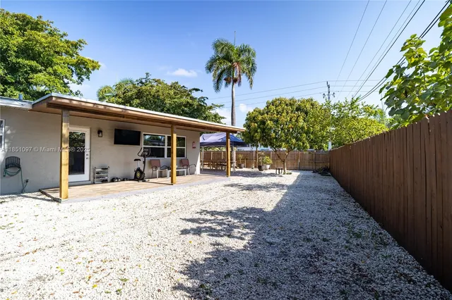 a view of a house with backyard and a tree