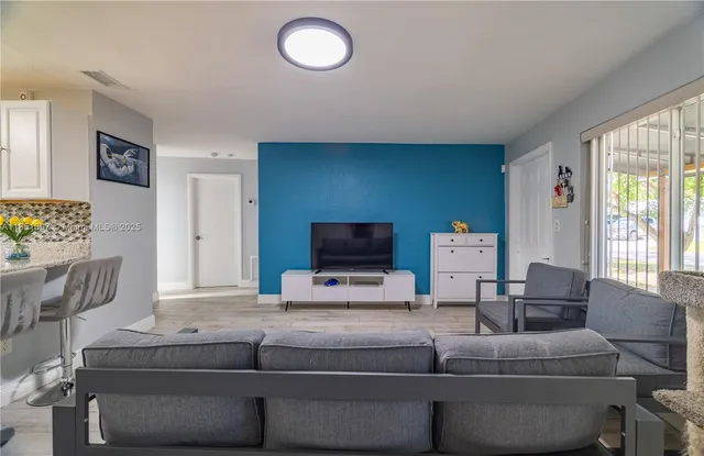 a kitchen with kitchen island granite countertop a table chairs sink and cabinets