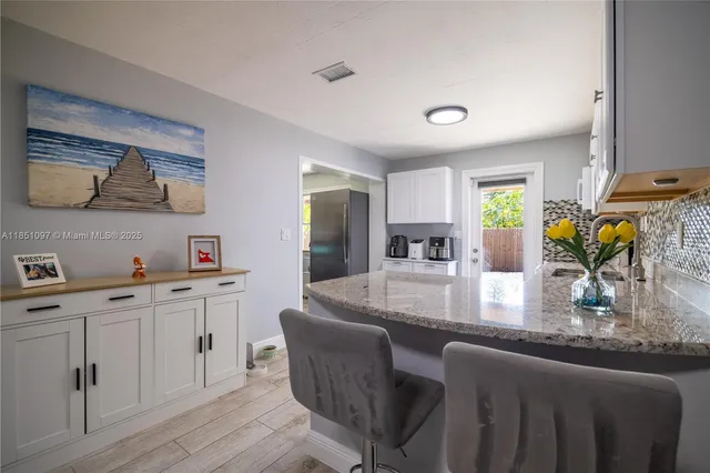 a kitchen with a refrigerator sink and cabinets