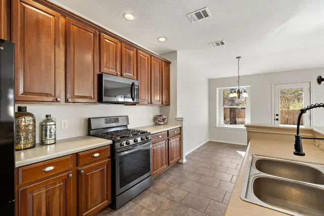 a kitchen with stainless steel appliances granite countertop a sink stove and cabinets