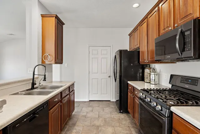a kitchen with stainless steel appliances granite countertop a refrigerator stove and sink