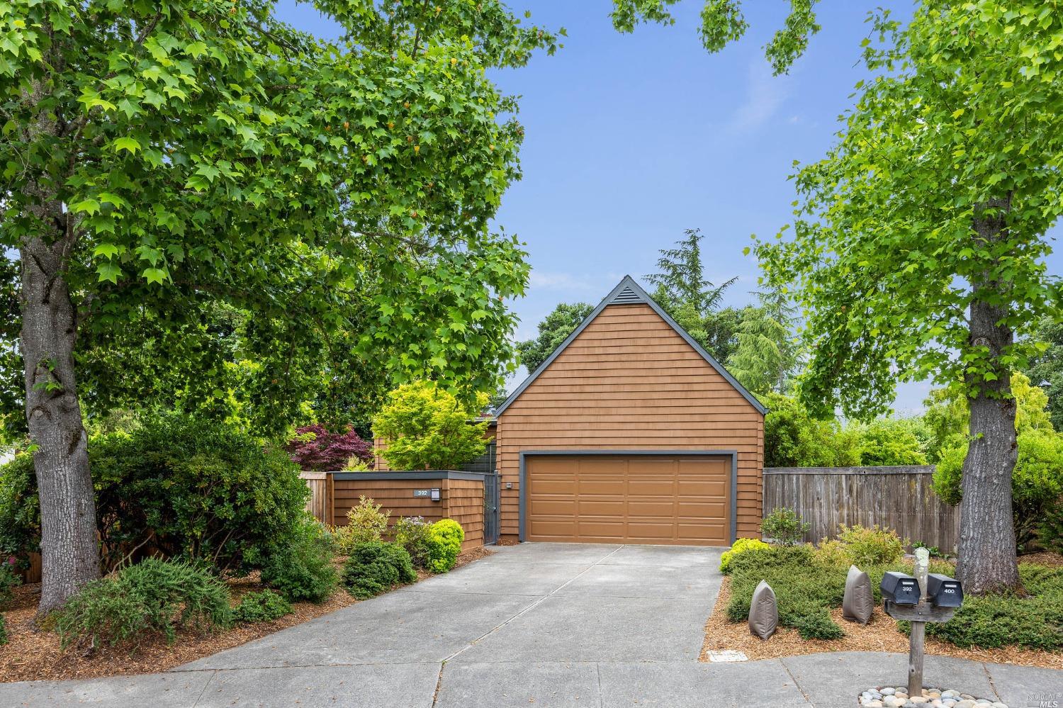 a front view of a house with plants and garden