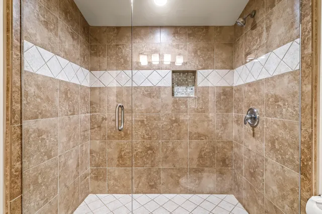 a spacious bathroom with a granite countertop tub sink a mirror a vanity and shower