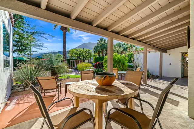 a view of patio with a table and chairs and potted plants