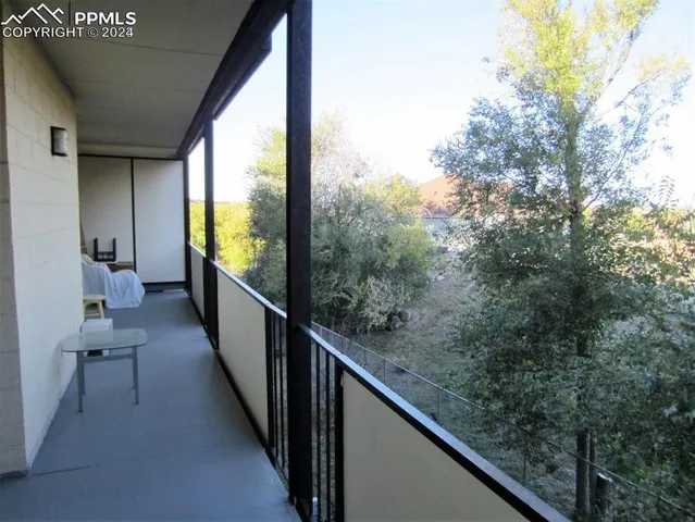 a view of a balcony with wooden floor and bench