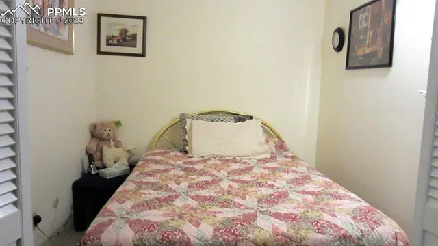 a bedroom with a bed and painting on the wall