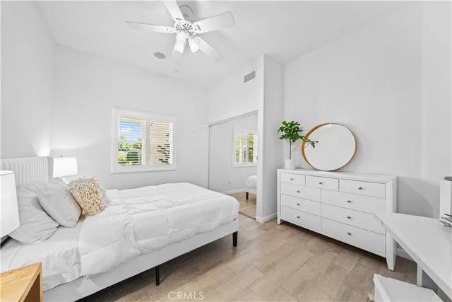 a bedroom with a bed a chandelier and a dresser