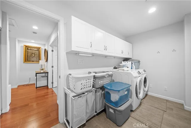 a utility room with cabinets washer and dryer
