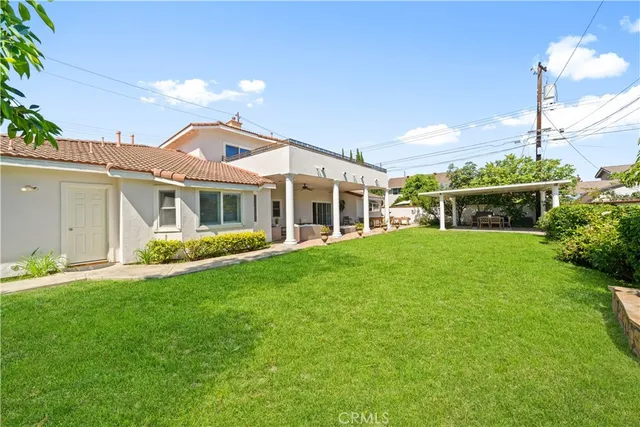 a view of an house with backyard space and balcony