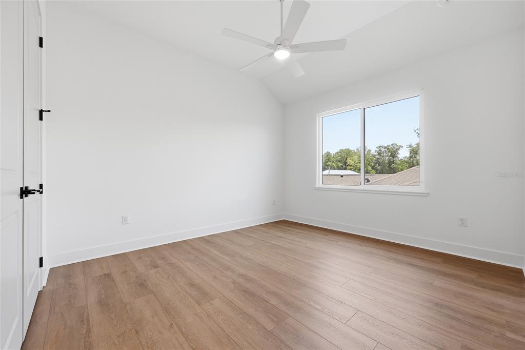 1063 Southwest 135th Way Newberry, FL 32669 - Photo 34 of 42 an empty room with wooden floor chandelier fan and windows