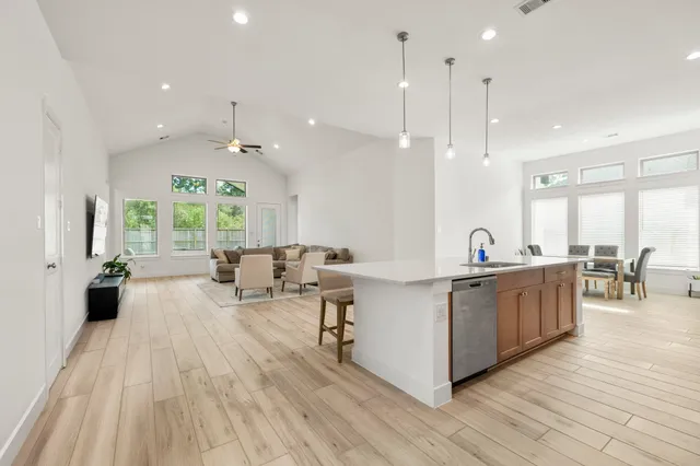 a large kitchen with stainless steel appliances a large center island attached withe living room