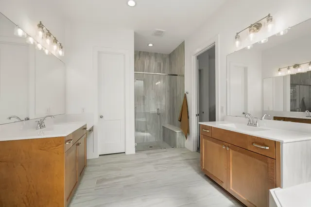a bathroom with a granite countertop sink a large mirror and a shower