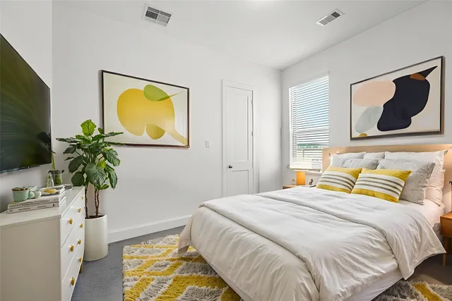 a bedroom with a bed and a potted plant