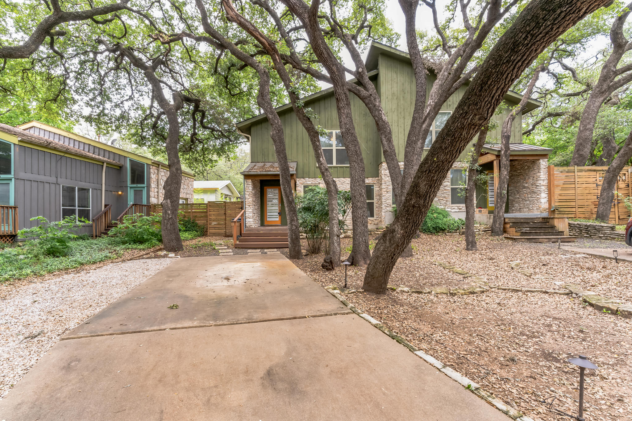 3214 Clawson Road, Unit A Austin, TX 78704 - Photo 21 of 26 Mature trees shade this welcoming home, featuring stone accents and an inviting entryway.