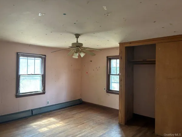 an empty room with windows and closet