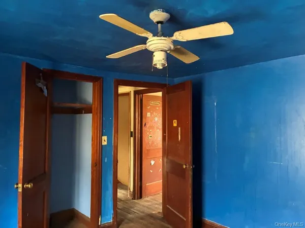 a view of a livingroom with a chandelier fan and a large window