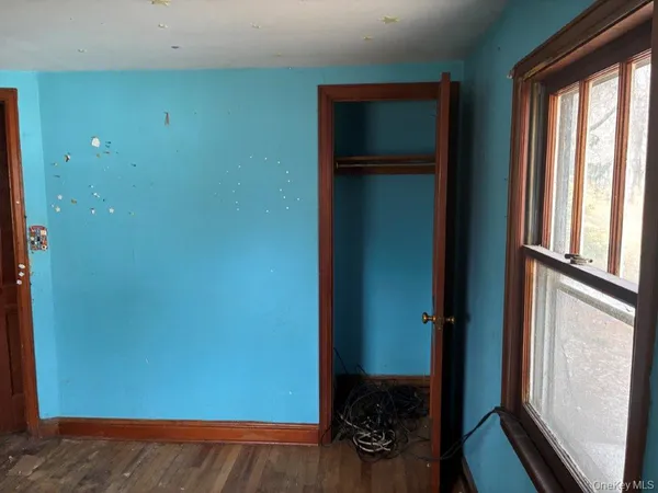 a view of a hallway with wooden floor and a bedroom