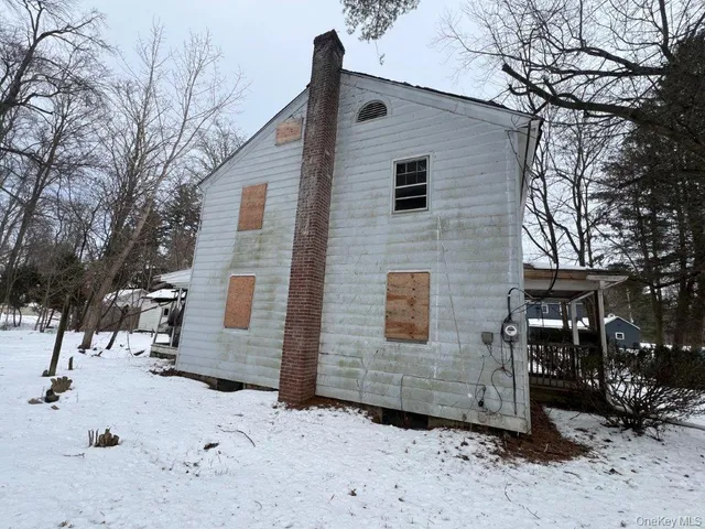 a view of a house with a yard covered in snow