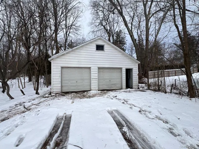 a front view of a house with a yard covered in snow