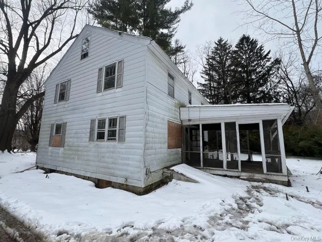 a view of a house with a yard covered in snow