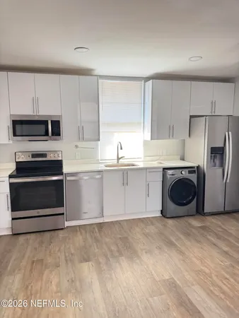 a kitchen with stainless steel appliances a refrigerator sink and cabinets