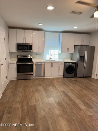 a large kitchen with a stove a refrigerator and a sink