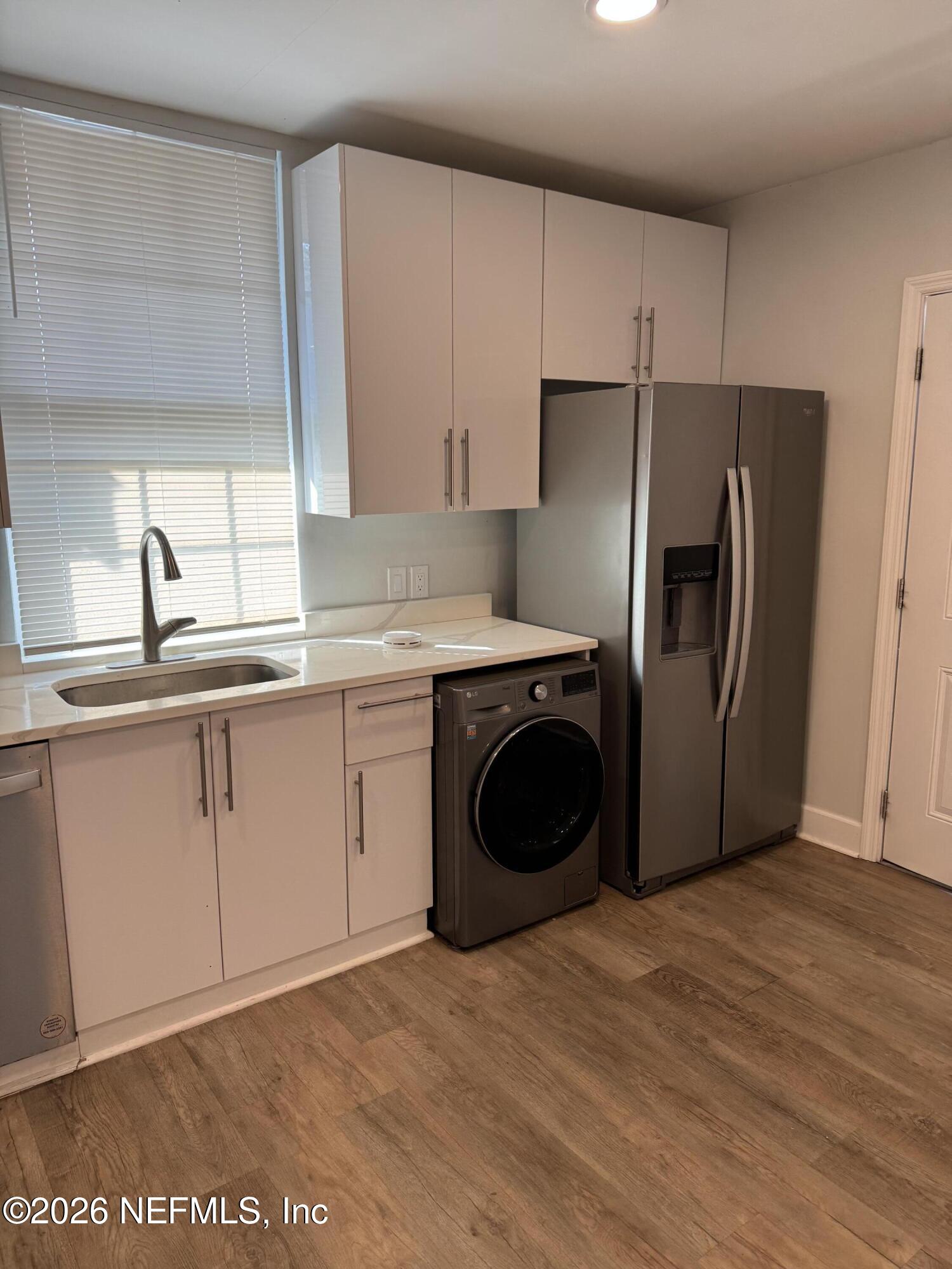 2357 College Street Jacksonville, FL 32204 - Photo 5 of 12 a kitchen with a sink a refrigerator and cabinets