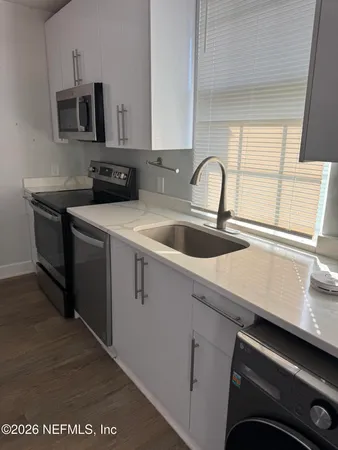 a kitchen with stainless steel appliances a sink a stove and a microwave