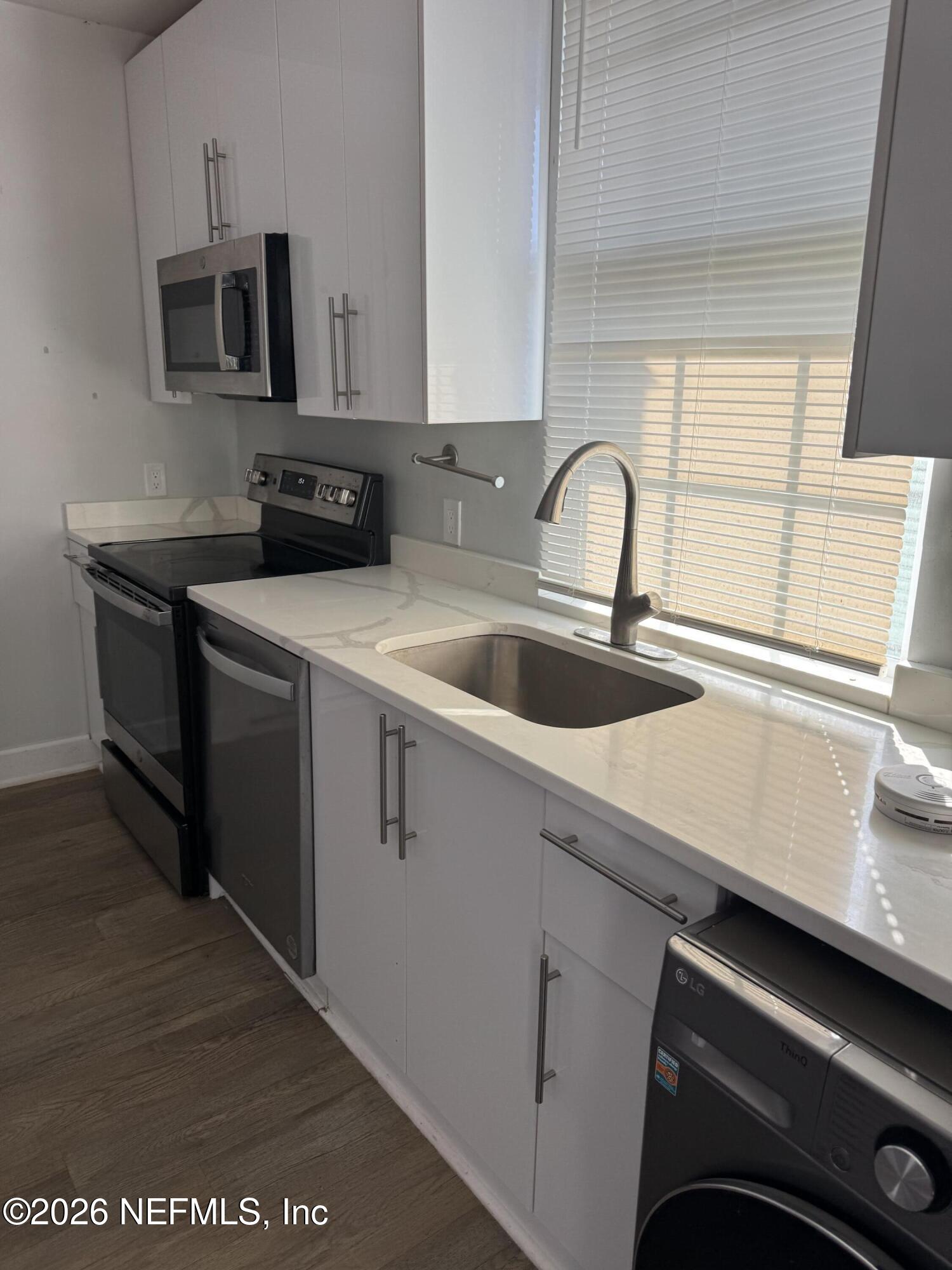2357 College Street Jacksonville, FL 32204 - Photo 6 of 12 a kitchen with stainless steel appliances a sink a stove and a microwave