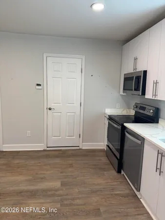 a kitchen with granite countertop a sink and a stove top oven