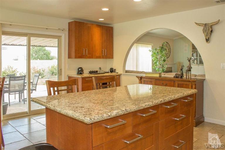 6360 Keystone Street Simi Valley, CA 93063 - Photo 3 of 17 a kitchen with a stove a sink a dining table and chairs with wooden floor