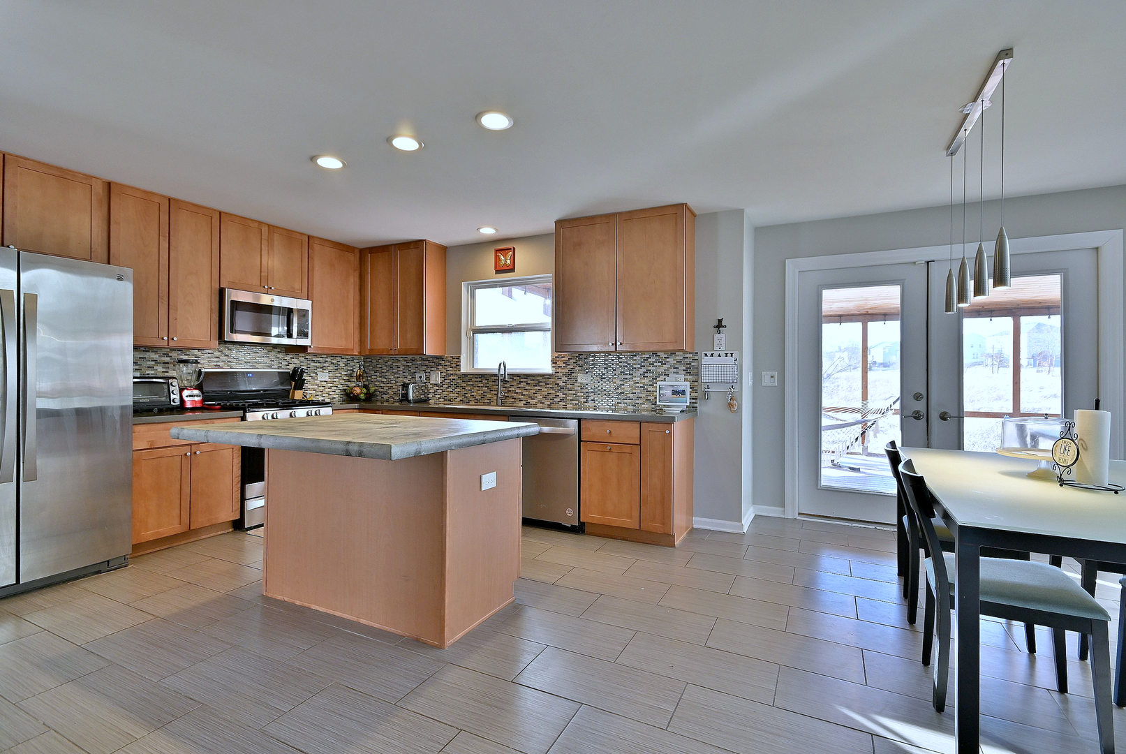 579 Homestead Court Aurora, IL 60506 - Photo 18 of 45 a kitchen with stainless steel appliances granite countertop a stove a sink a microwave a dining table and chairs