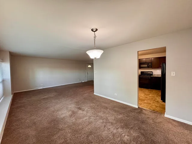 an empty room with an empty space and a chandelier fan