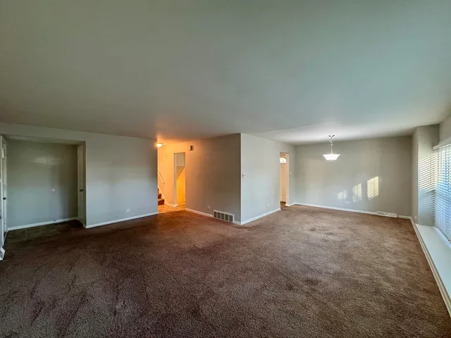 a view of an empty room with window and a fireplace