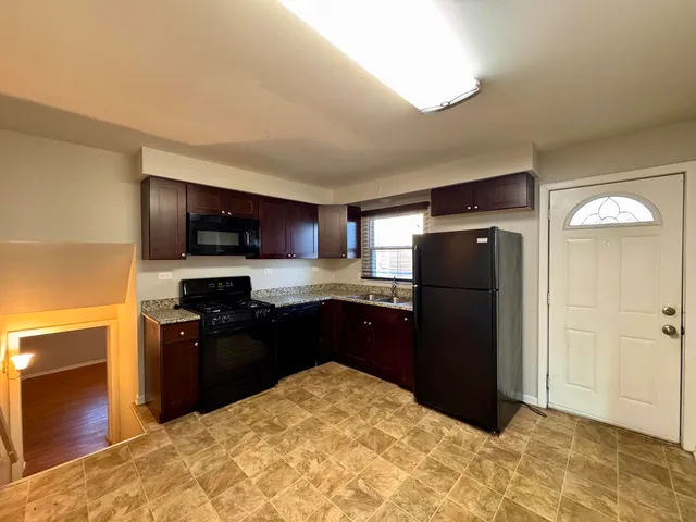 a kitchen with stainless steel appliances granite countertop a refrigerator and a stove top oven