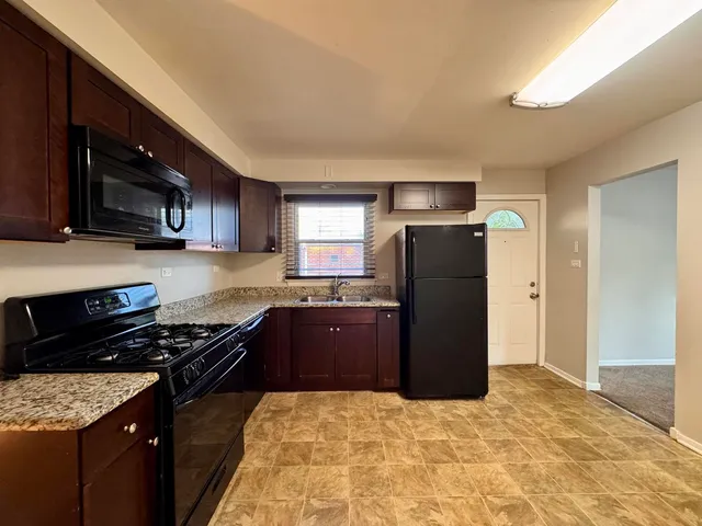 a kitchen with a refrigerator and a stove top oven