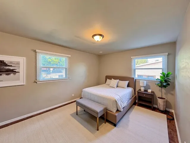 a bedroom with a bed and a potted plant