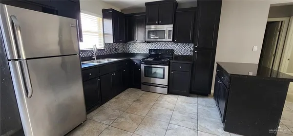 a kitchen with a refrigerator sink and stove