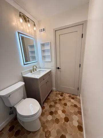 a bathroom with a sink a toilet a mirror and shower