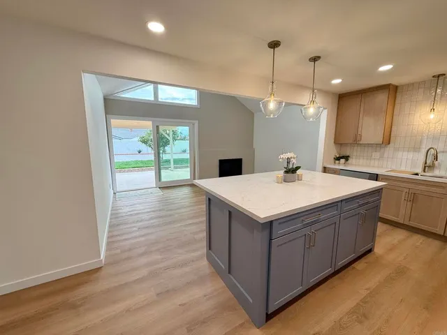 a kitchen with a sink and wooden floor
